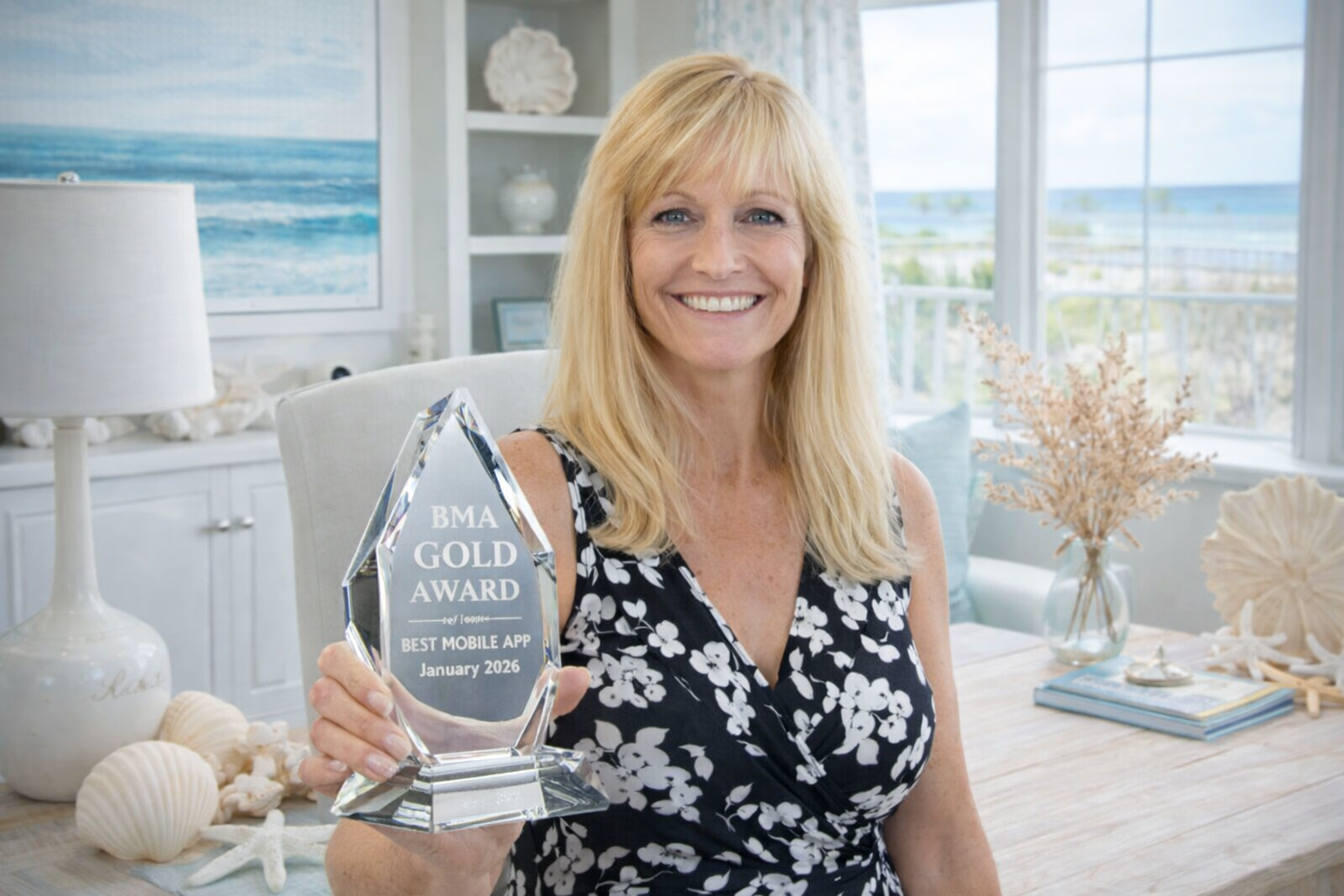 Dawn Lindsay, founder and CEO of the Beach Buddy App, holding the 2026 Best Mobile App Gold Award