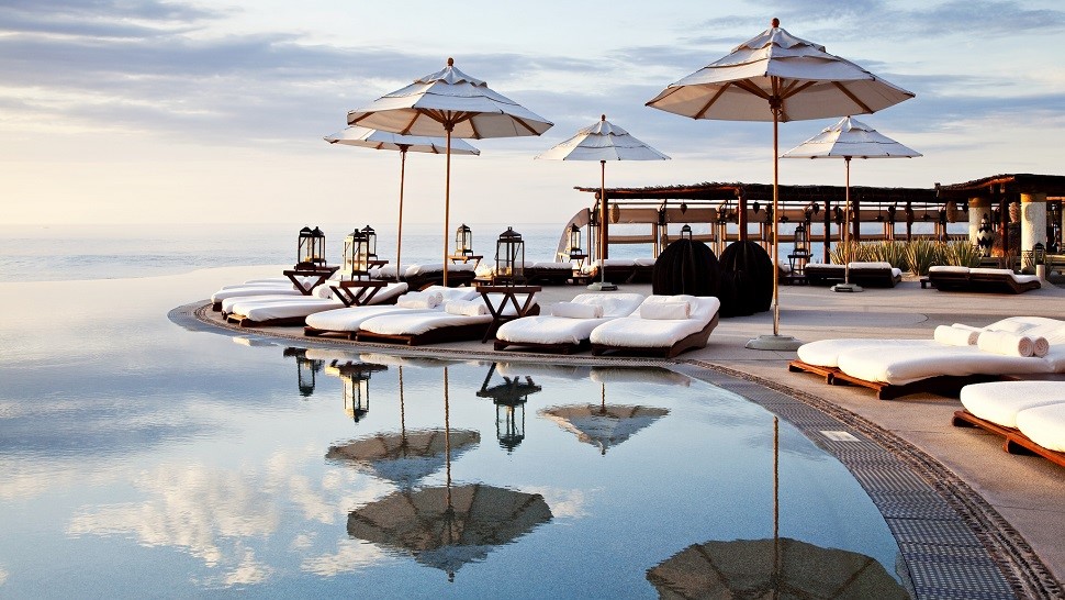 Luxury coastal resort with poolside lounge chairs